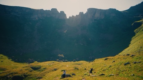 Two hikers below a rocky cirque, graded with the Alpine Gold LUT